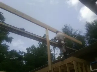 Carpenter setting a ridge beam over a new addition frame — Ice Dam Removal by Roofing Brothers in Strasburg